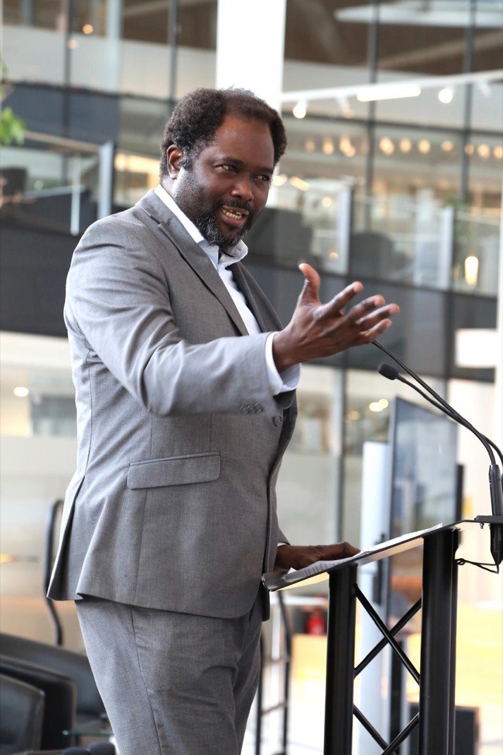 Ayo Akande gesturing at a lectern